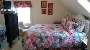 A bedroom with a bed, a dresser, a chair, a desk, and a window.