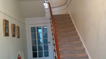 A staircase with a checkered floor leading to a door with frosted glass panels.