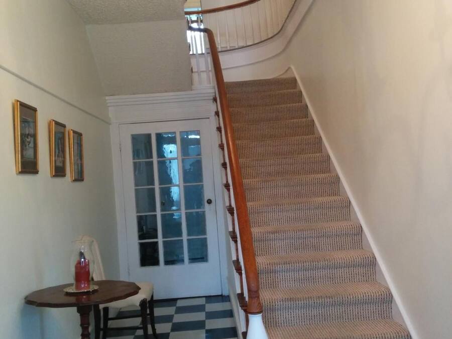 A staircase with a checkered floor leading to a door with frosted glass panels.