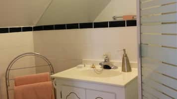 Un bagno con un lavandino bianco, un portasciugamani con un asciugamano rosa e un water.
