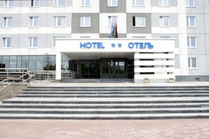 A hotel entrance with a sign reading "HOTEL" and a flag above it.