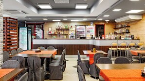 A restaurant with a bar area, seating, and a variety of beverages.