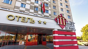 A hotel entrance with a large sign reading "OTEHL" and "IMPEX HOTEL" with a star logo.