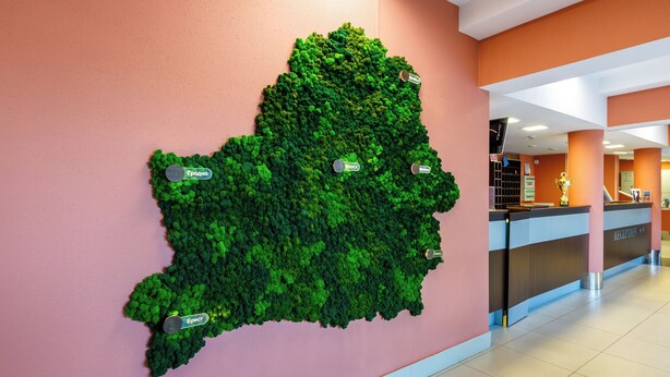 A reception area with a green wall installation and a reception desk.