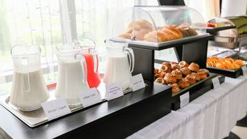 Buffet com bebidas e doces identificados.