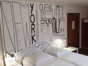 A hotel room with a large wall mural featuring city names and landmarks. - Hotel des bois (Seltz)