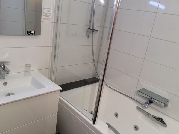 A modern bathroom with a glass shower enclosure, a white sink, and a bathtub. - Hotel des bois (Seltz)