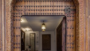 An ornate wooden door with a geometric patterned floor. - Dar Fes Medina Ziat (Fes)