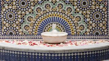 Uma fonte de azulejos rodeada por um chão e uma parede estampados.
