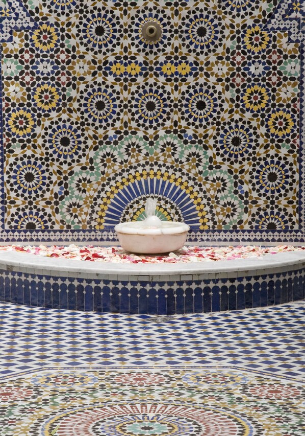 Uma fonte de azulejos rodeada por um chão e uma parede estampados.