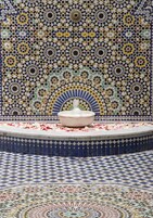 Uma fonte de azulejos rodeada por um chão e uma parede estampados.