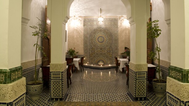 A traditional Moroccan interior with intricate tile work, a central fountain, and seating areas. - Dar Fes Medina Ziat (Fes)
