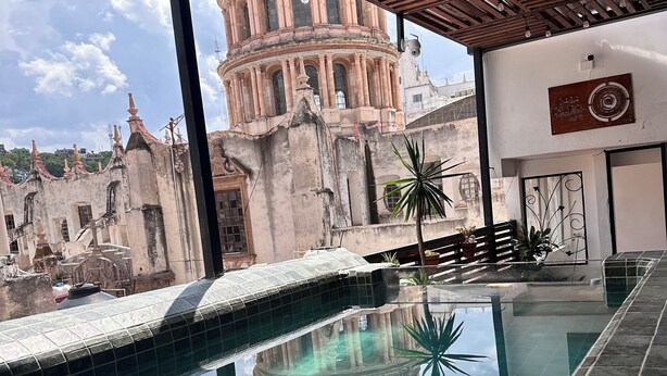 Un espace piscine offrant une vue sur un bâtiment historique doté d’un dôme.
