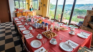 A dining area with a red tablecloth, white plates, and a variety of breakfast items. - La Casa Rossa Country House (Piazza Armerina)