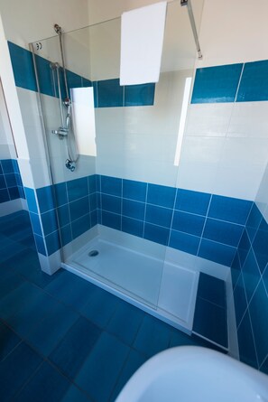 Habitación triple | Baño | Ducha, artículos de higiene personal gratuitos y secador de pelo