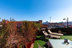 A rooftop terrace with lounge chairs, a small table, and potted plants. - Marina ResArt B&B (Naples)
