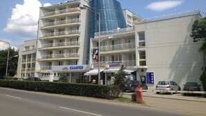 Un hotel de diseño moderno, con una llamativa torre cilíndrica de cristal y varios balcones.