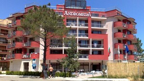 A multi-story hotel with balconies, a central atrium, and a clear sky. - Hotel Andromeda - All inclusive (Sunny Beach)
