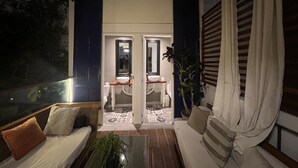 A cozy balcony with a sofa, a small table, and a potted plant. - La casa del Viajero (Lima)