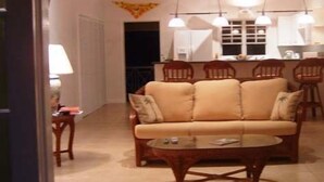 Una sala de estar con un sofá, una mesa de centro y un comedor con sillas.