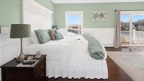 A bedroom with a bed, a nightstand, a lamp, a window, and a view of the outside. - The Beacon Waterfront Inn (Hull)