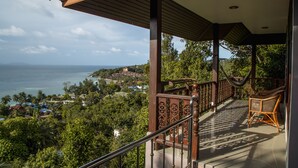A balcony with a view of the sea and a town. - Haad Yao Over Bay Resort (Ko Pha-ngan)