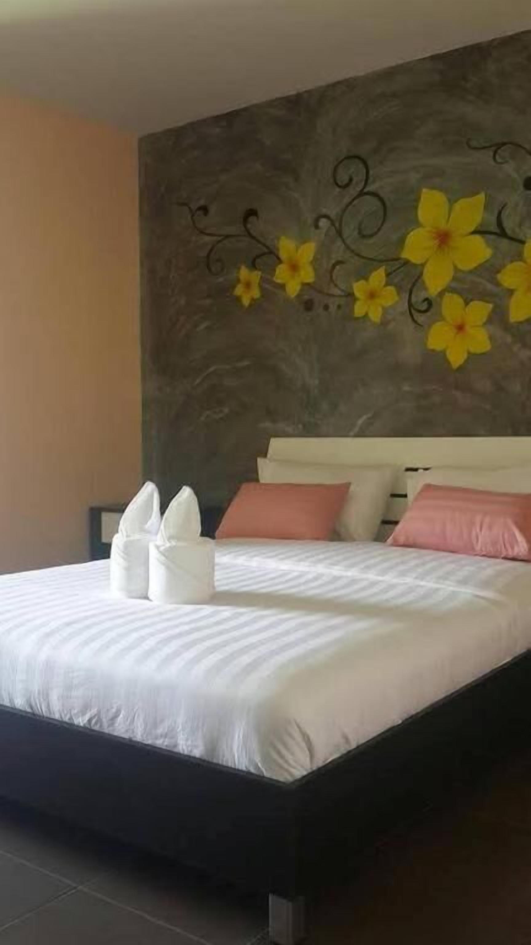 Un dormitorio con una cama grande, ropa de cama blanca y decoración en la pared.