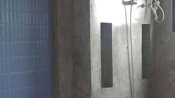 A bathroom with a shower, a towel rack, and a mirror.