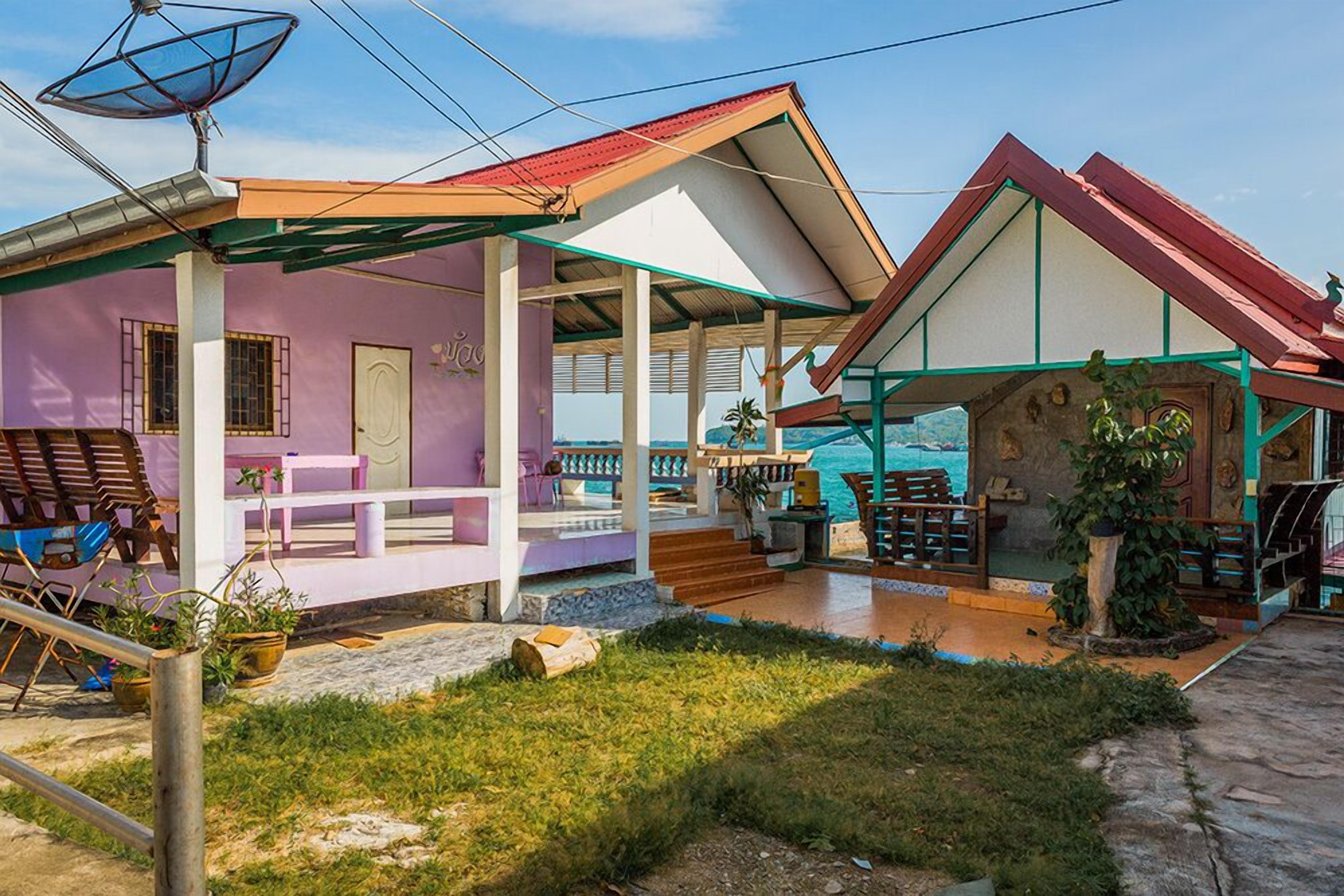 A two-story building with a covered patio area, outdoor seating, and a satellite dish.