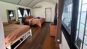 A room with two beds, a mirror, a small table, and a window with curtains. - Rimtalay Resort Koh Si Chang (Ko Sichang)