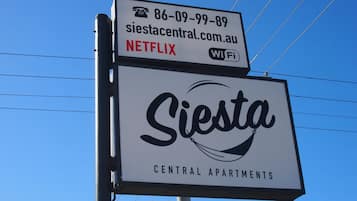 A sign for Siesta Central Apartments advertising Netflix and WiFi.