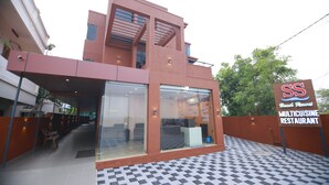A modern building with a checkered floor, a staircase, and a sign for a multicuisine restaurant.