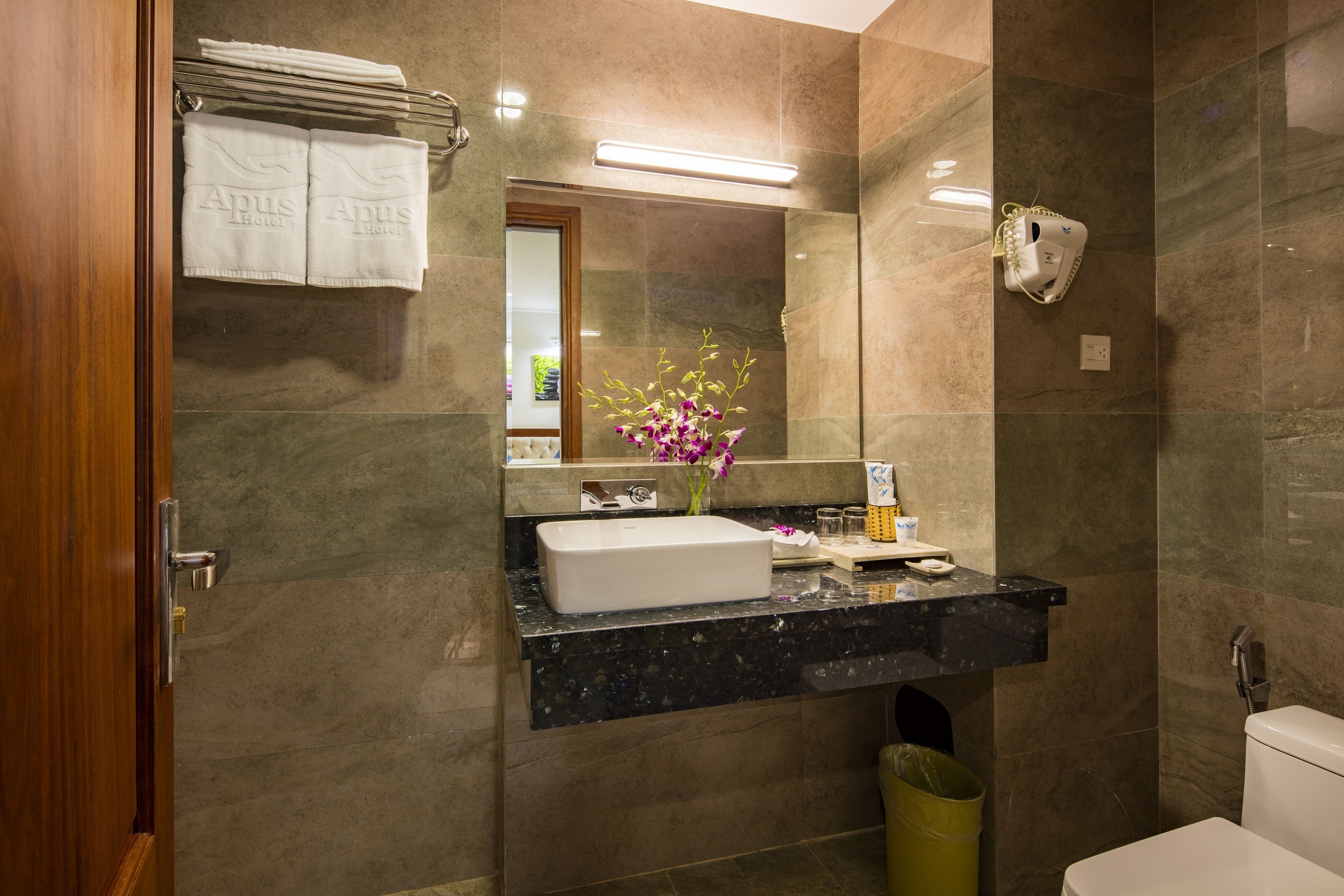 Une salle de bain moderne avec un lavabo en marbre, un miroir et des toilettes.