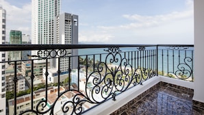 Un balcón con vista a la playa y edificios altos.