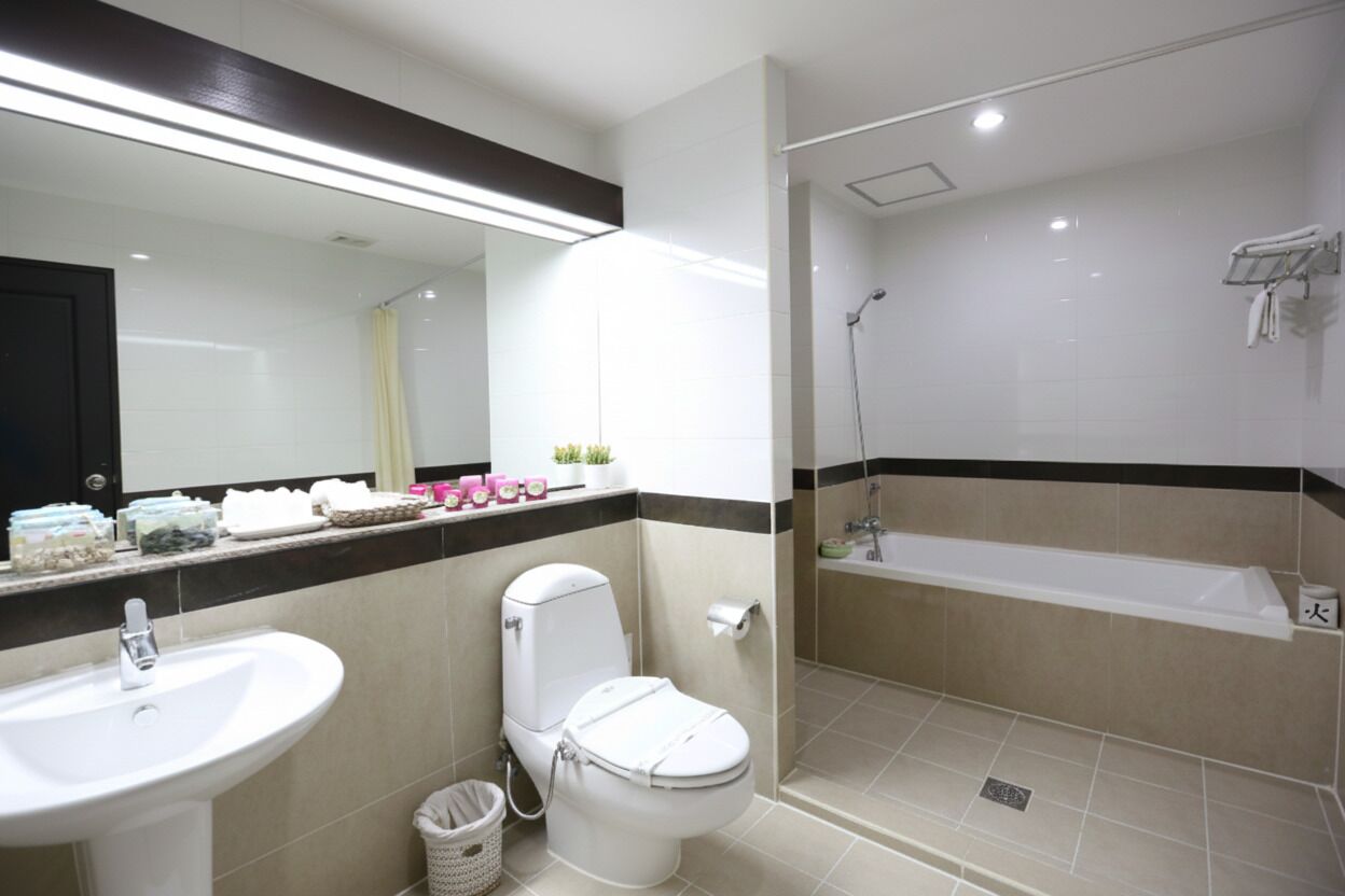 A modern bathroom with a sink, toilet, and shower area.