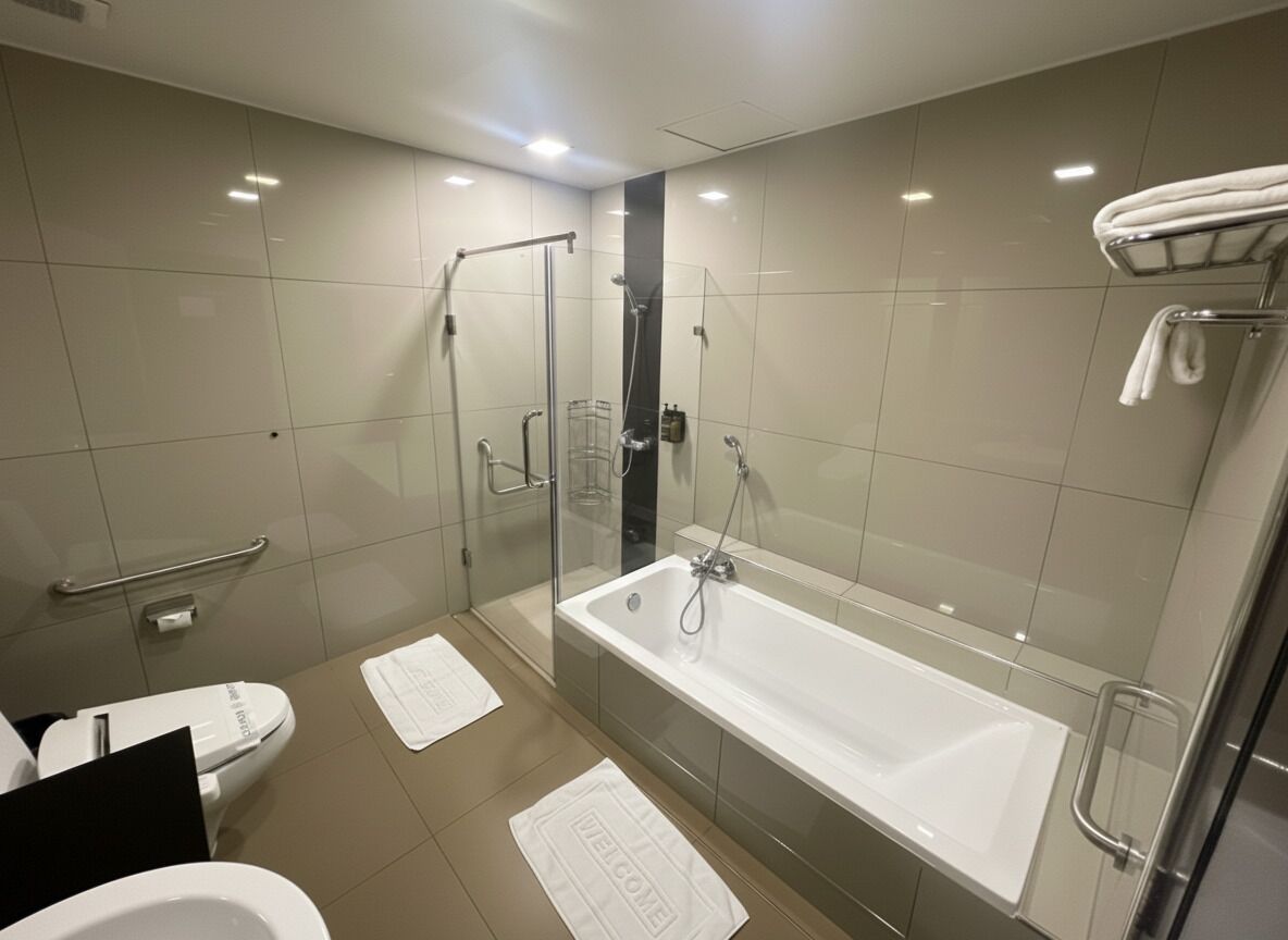 Un baño moderno con ducha acristalada, bañera independiente y un inodoro.