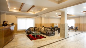 A spacious lobby with a reception desk, seating area, and a stone pillar. - Pokhara Choice Inn (Pokhara)
