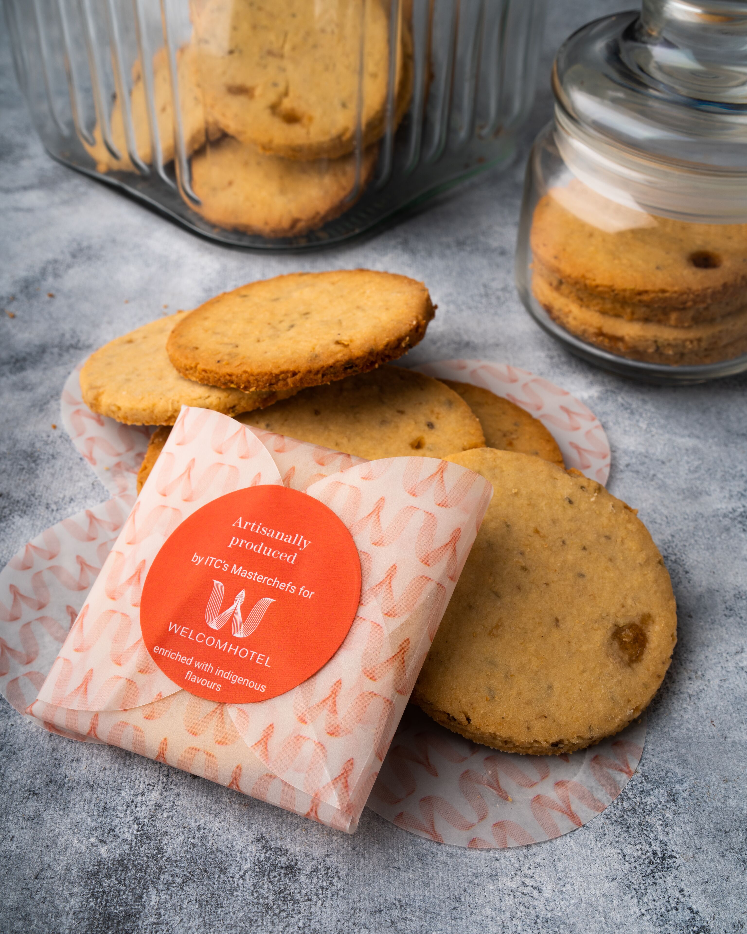 A package of WelcomHotel cookies with a label indicating they are artisanal and produced by ITC's Masterchefs for WelcomHotel, enriched with indigenous flavors.