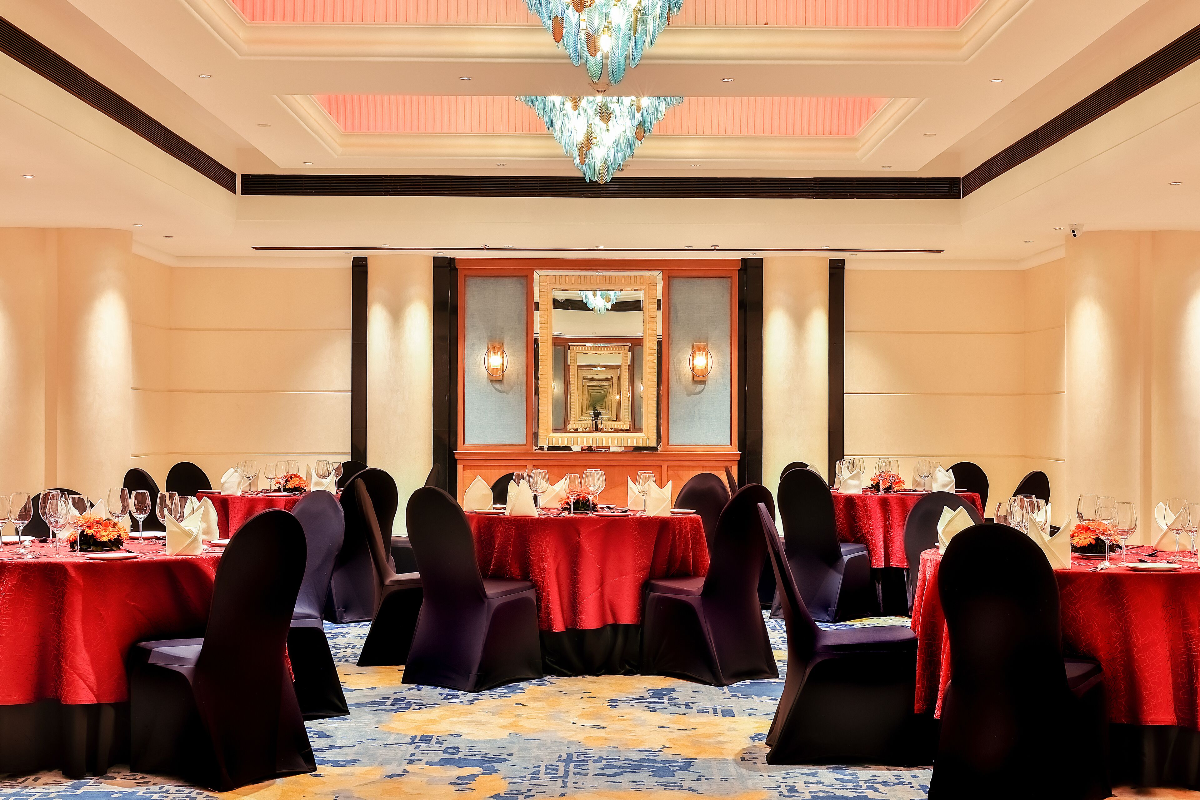 A banquet hall with multiple tables set for dining, each with chairs and table settings.