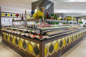 Un bufé con diversos alimentos y jarrones decorativos.