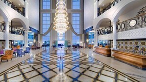 A spacious lobby with a grand chandelier, multiple seating areas, and a check-in counter. - Litore Resort Hotel & Spa - All Inclusive (Alanya)