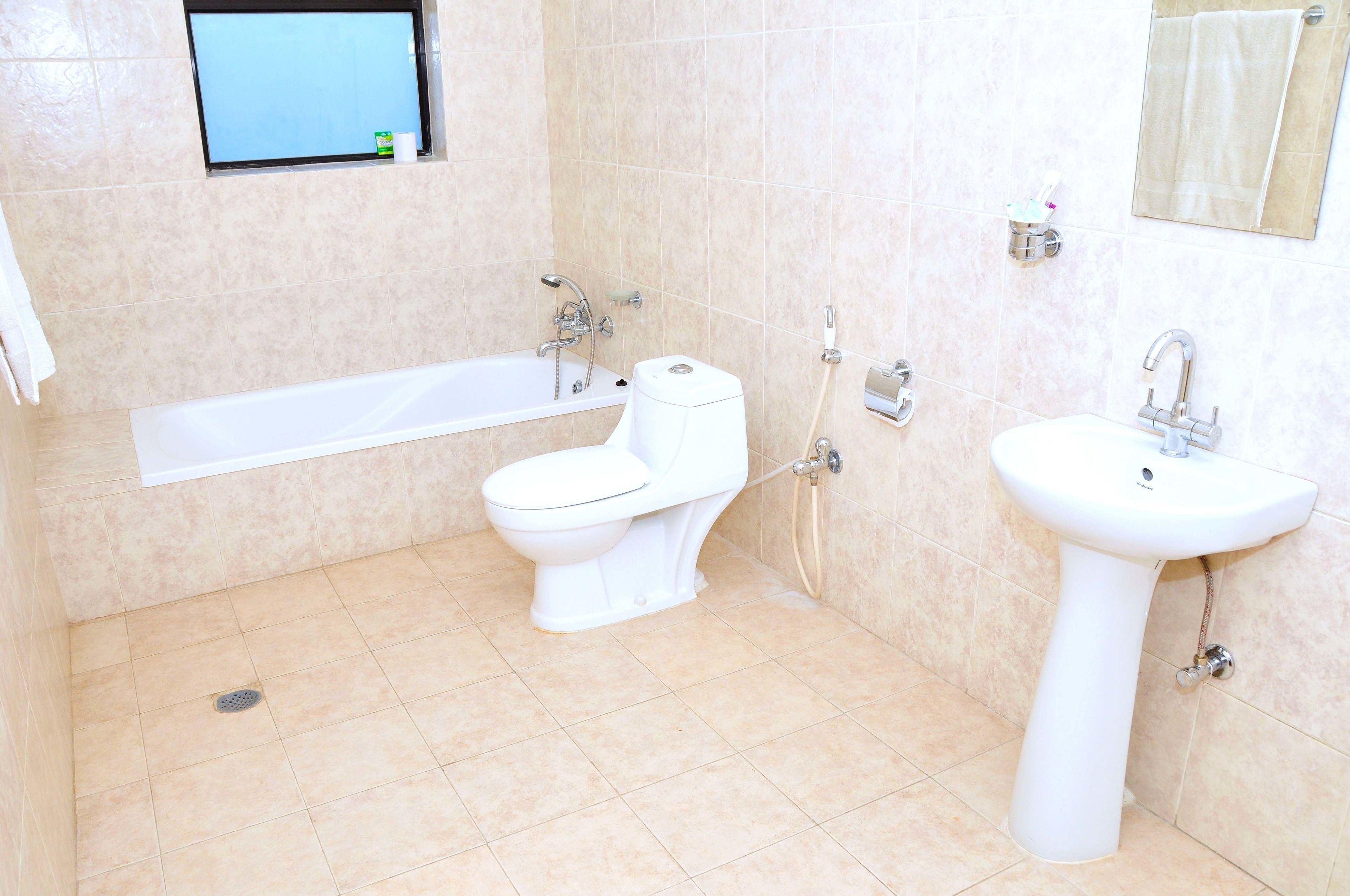 A bathroom with a bathtub, toilet, and sink.