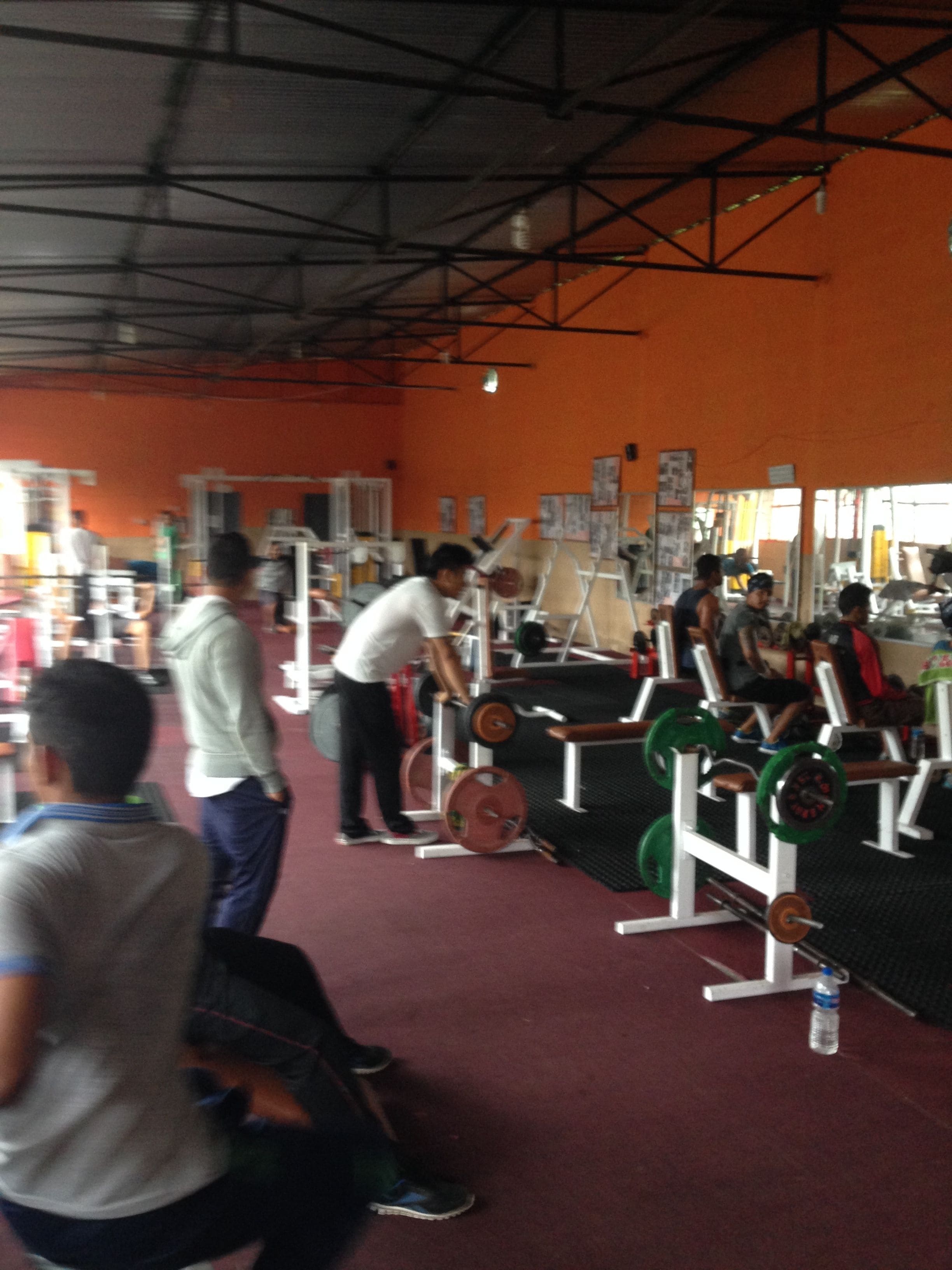 A gym with various exercise equipment, including weight machines and free weights.