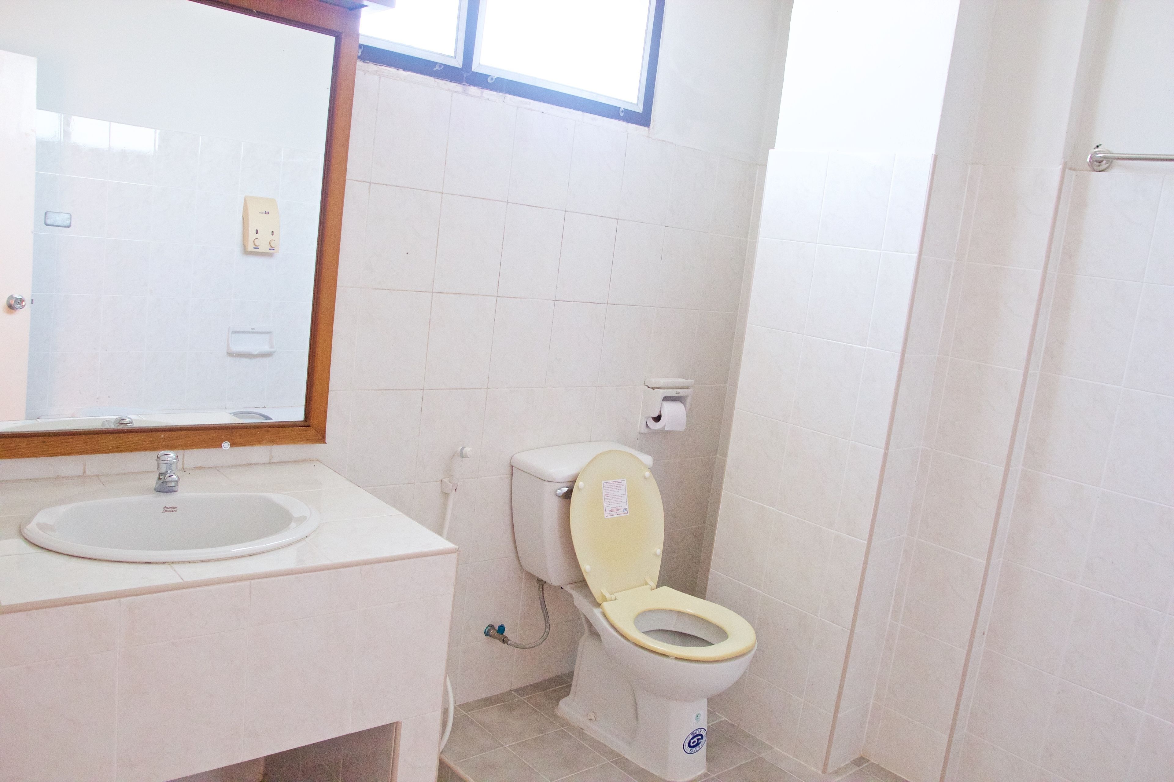 Un bagno con lavandino, WC e specchio.
