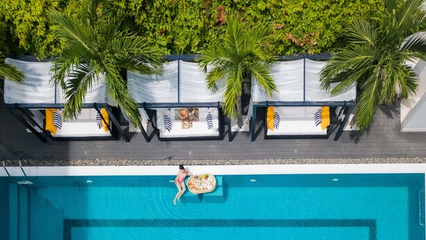 An aerial view of a swimming pool with lounge chairs and palm trees. - Hoian Sincerity Hotel & Spa (Da Nang)