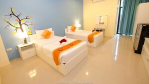 A hotel room with two beds, a nightstand with a lamp, a wall-mounted air conditioner, a mirror, and a view of a hallway with a curtain. - Petch Ranong at Town (Ranong)