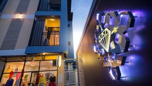 A modern building with a glass storefront displaying clothing. - Petch Ranong at Town (Ranong)