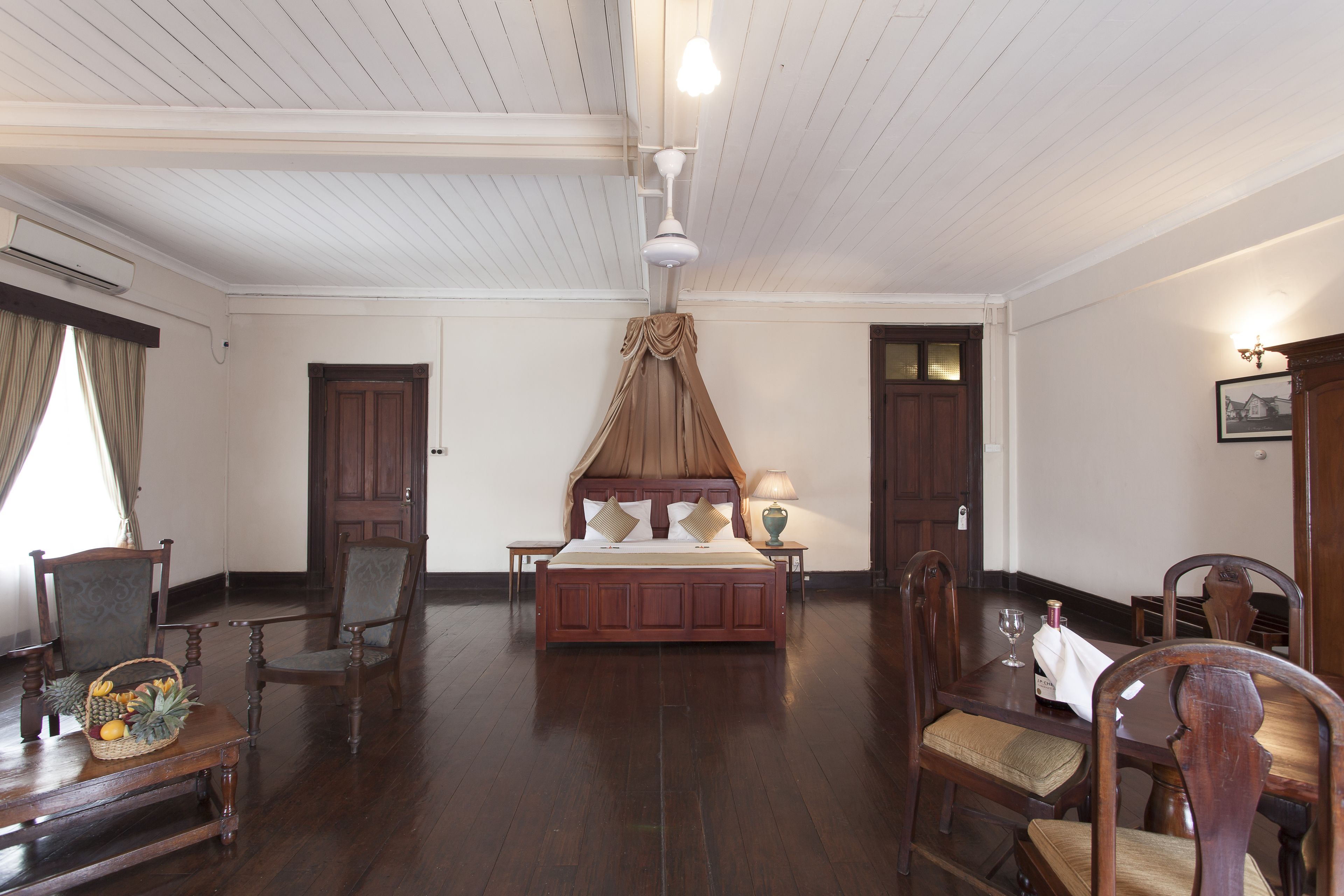 Une chambre de style traditionnel, avec un lit en bois, une table à manger et des chaises.