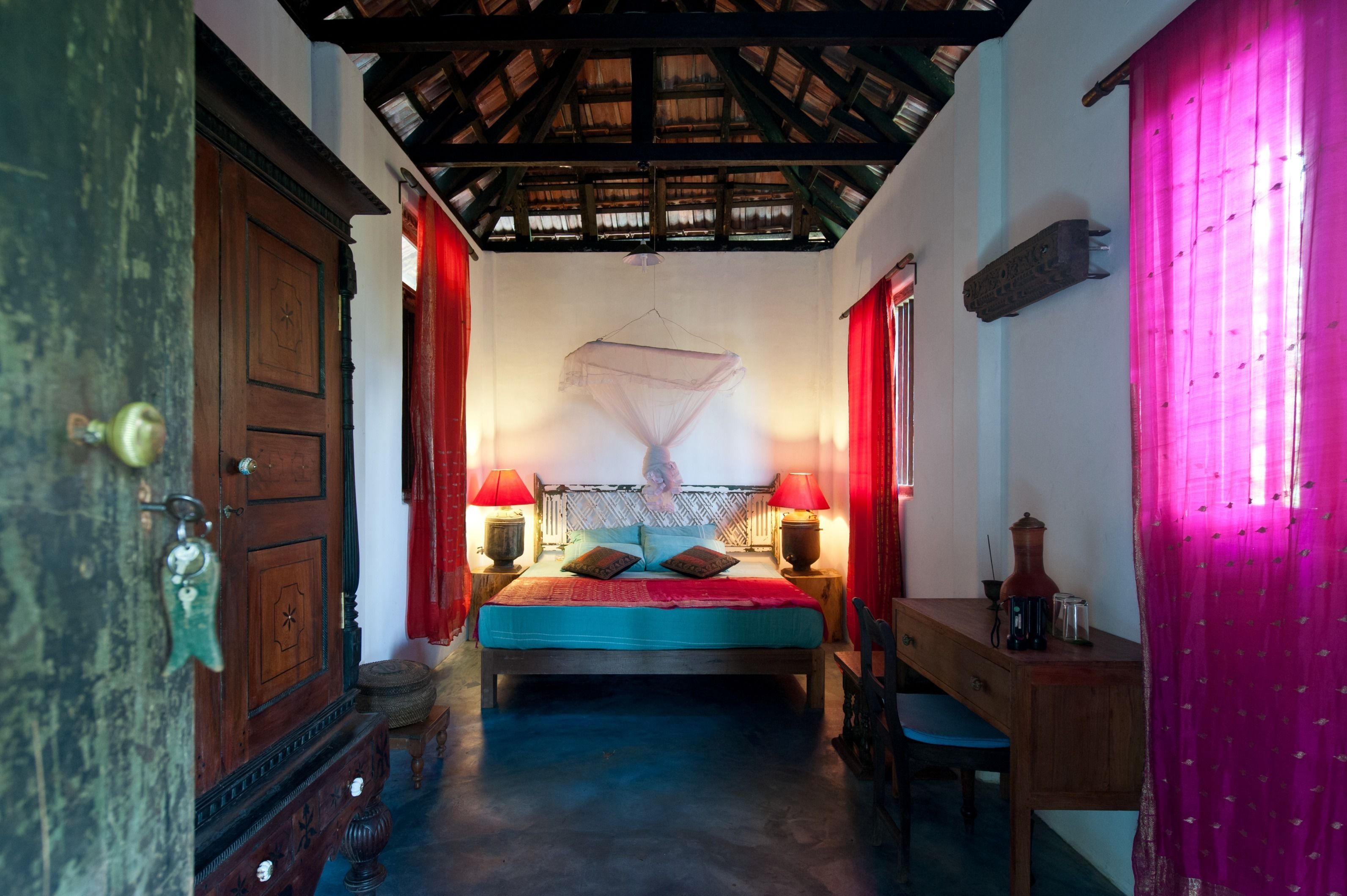 Ein traditionell eingerichteter Raum mit einem Bett, Holzmöbeln und einer Decke mit sichtbaren Balken.