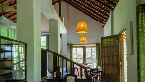 A spacious interior with a high ceiling, wooden beams, and a staircase leading to upper levels. - The Kandy Samadhi Centre (Kundasale)